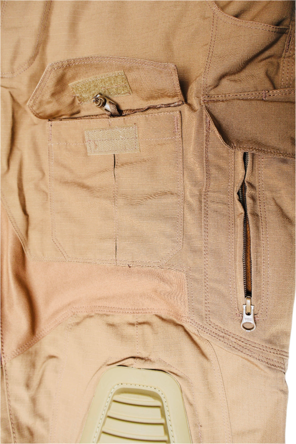Close-up of a tan military-style Zipper pocket and knee hight adjustment with zippers and patches.