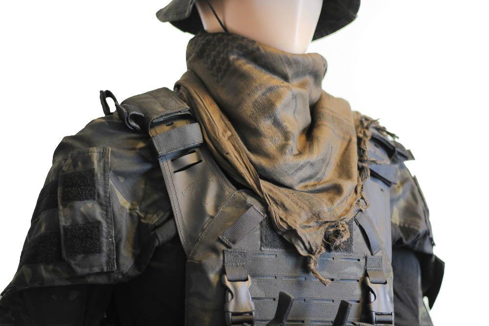 A person wearing a camouflage tactical military scarf on their head and neck.